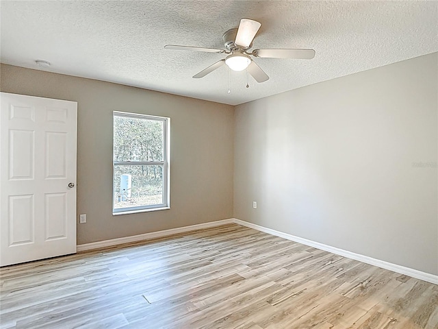 empty room with light wood-style flooring, a textured ceiling, ceiling fan, and baseboards
