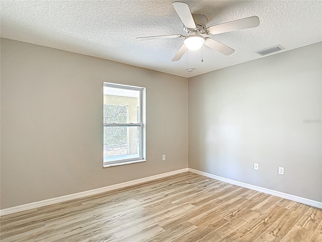 unfurnished room with light wood-type flooring, baseboards, a textured ceiling, and a ceiling fan