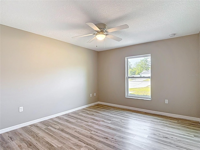 spare room with light wood-style floors, ceiling fan, a textured ceiling, baseboards, and a smoke detector