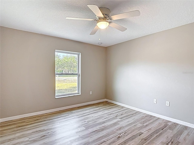 unfurnished room with light wood finished floors, baseboards, a textured ceiling, and ceiling fan