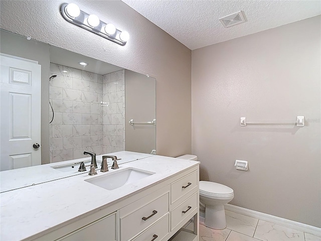 full bath featuring marble look tiles, toilet, vanity, baseboards, and tiled shower