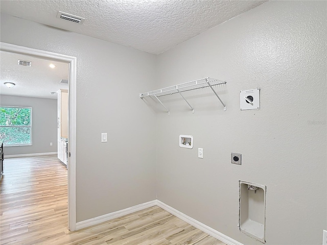 laundry room featuring hookup for a washing machine, a textured ceiling, electric dryer hookup, light wood finished floors, and baseboards