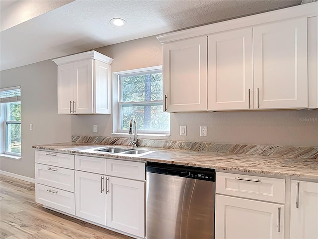 kitchen featuring dishwasher, a sink, light wood-style flooring, white cabinetry, and light stone countertops