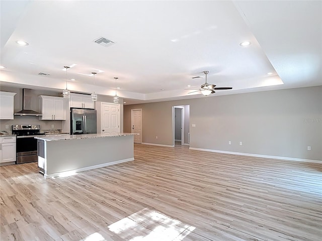 kitchen with appliances with stainless steel finishes, wall chimney range hood, recessed lighting, baseboards, and light wood-style floors