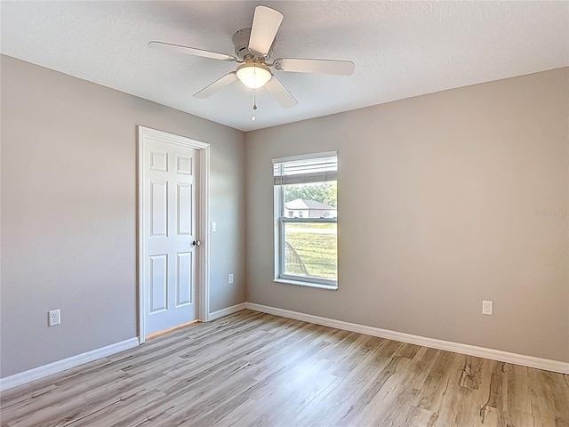 unfurnished room featuring light wood-style floors, baseboards, a textured ceiling, and ceiling fan