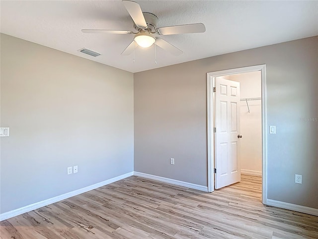 empty room featuring a ceiling fan, light wood-style flooring, and baseboards