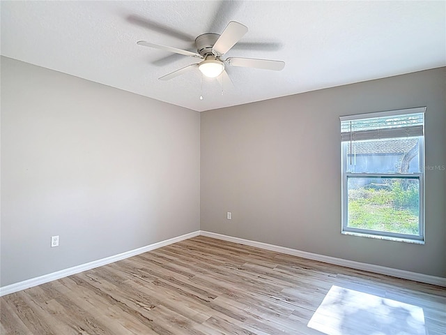 unfurnished room featuring light wood-type flooring, baseboards, and a ceiling fan