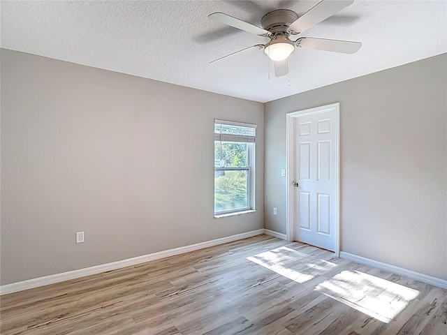 unfurnished bedroom with light wood-type flooring, baseboards, ceiling fan, and a textured ceiling