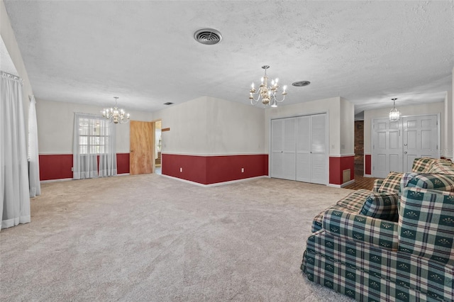 3441 Sherertz Rd, Lakeland, FL 33810 - unfurnished living room with a chandelier, carpet floors, baseboards, and a textured ceiling