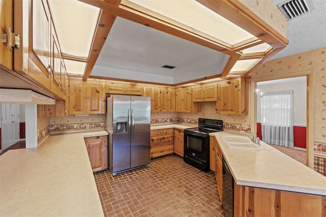 3441 Sherertz Rd, Lakeland, FL 33810 - kitchen with black appliances, a sink, a peninsula, wallpapered walls, and light countertops