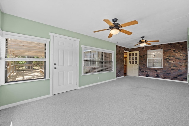 3441 Sherertz Rd, Lakeland, FL 33810 - spare room featuring baseboards, brick wall, a ceiling fan, carpet flooring, and healthy amount of natural light