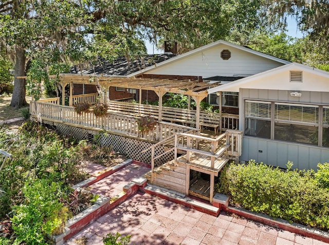 3441 Sherertz Rd, Lakeland, FL 33810 - rear view of property featuring a wooden deck, board and batten siding, and a patio area