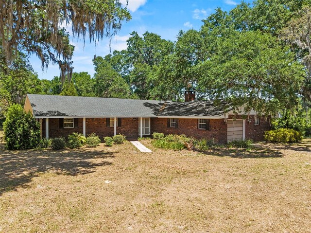 3441 Sherertz Rd, Lakeland, FL 33810 - ranch-style home with brick siding, a chimney, and a front yard