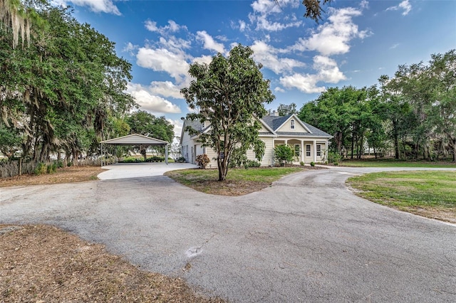 view of front of house featuring curved driveway, a front lawn, a porch, and a carport