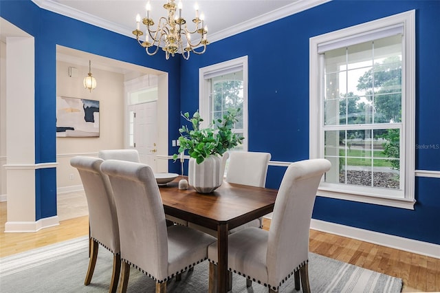 dining area featuring an inviting chandelier, ornamental molding, and wood finished floors