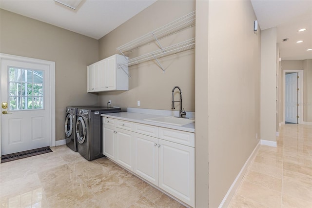 laundry area featuring baseboards, recessed lighting, separate washer and dryer, a sink, and cabinet space
