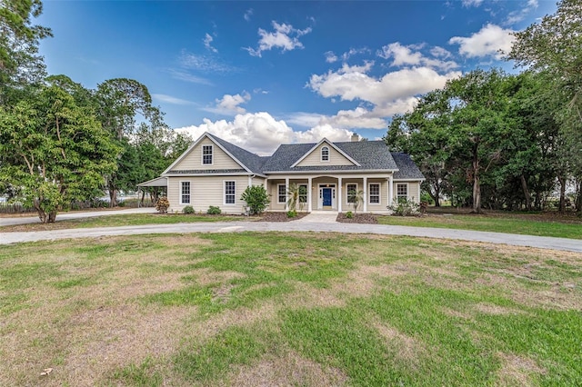 view of front of home with curved driveway, a porch, and a front yard
