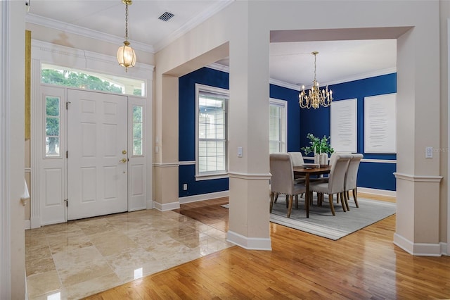 entrance foyer featuring an inviting chandelier, ornamental molding, and baseboards