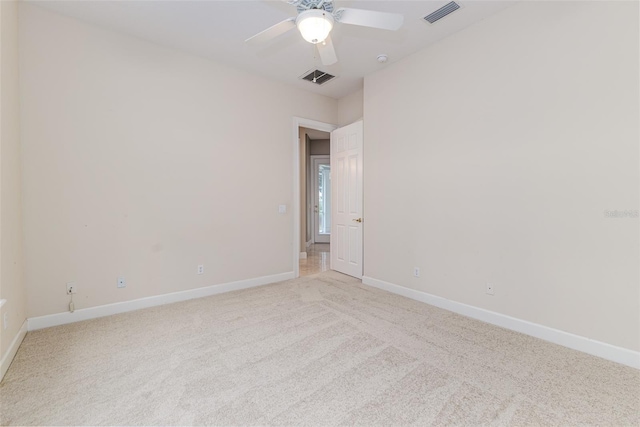 empty room with light colored carpet, baseboards, and visible vents