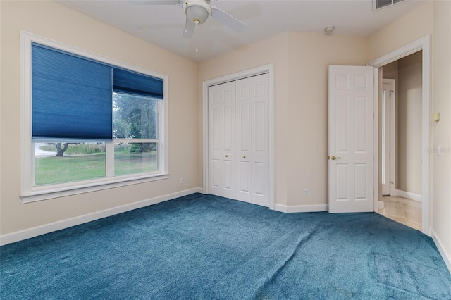 unfurnished bedroom featuring baseboards, a ceiling fan, carpet, and a closet