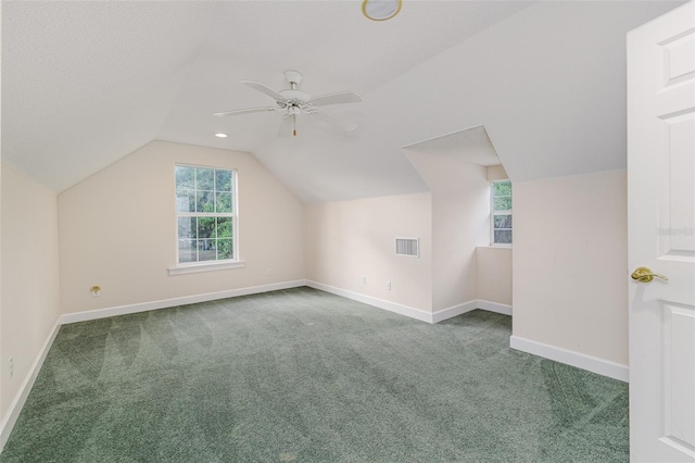 additional living space with carpet flooring, baseboards, visible vents, and vaulted ceiling