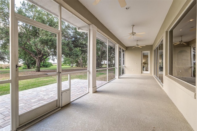 unfurnished sunroom with ceiling fan and a healthy amount of sunlight