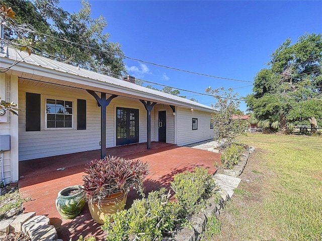 view of front facade with a porch, metal roof, and a front yard
