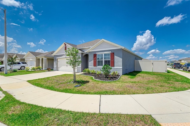 ranch-style house with driveway, an attached garage, stucco siding, a front lawn, and a gate