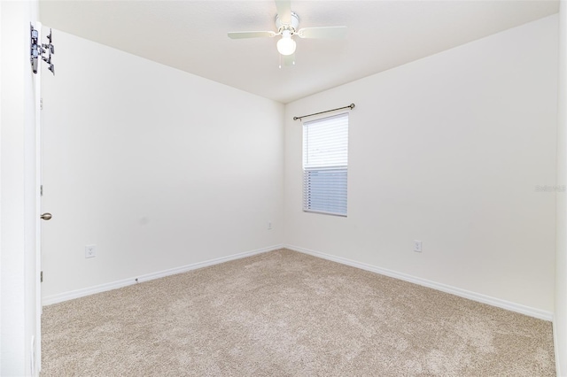 carpeted empty room featuring baseboards and a ceiling fan
