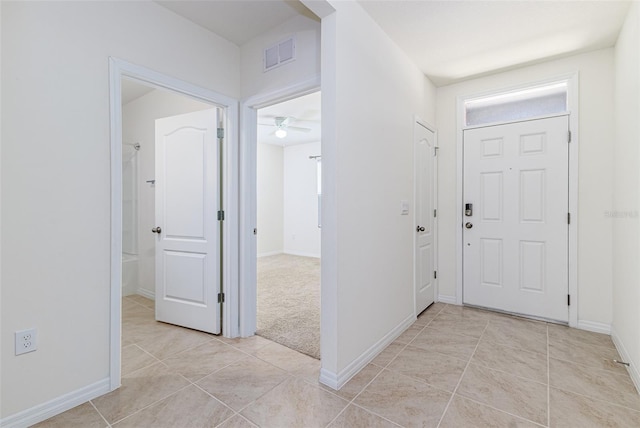 entrance foyer with light tile patterned floors, a ceiling fan, and baseboards