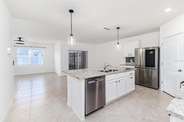 kitchen featuring light tile patterned flooring, appliances with stainless steel finishes, a sink, and decorative light fixtures
