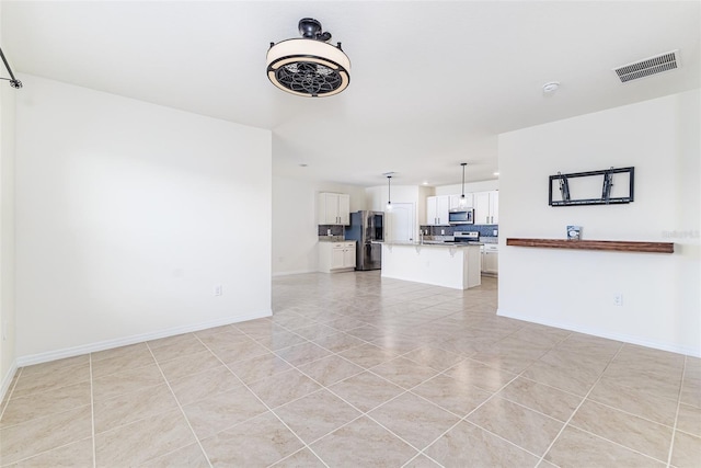 unfurnished living room with baseboards, visible vents, and light tile patterned flooring
