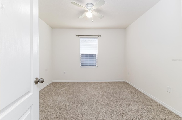 empty room with baseboards, ceiling fan, and light colored carpet