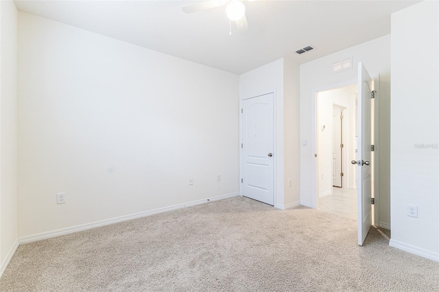 unfurnished bedroom featuring baseboards, ceiling fan, light carpet, and visible vents
