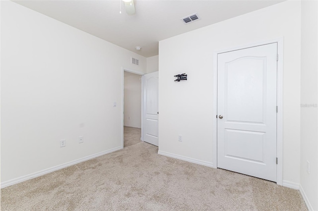 unfurnished bedroom with ceiling fan, carpet, baseboards, and visible vents