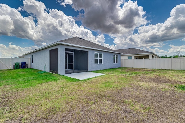 back of house featuring a fenced backyard, a patio, stucco siding, and a lawn