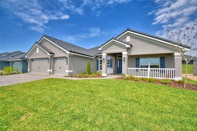 view of front of home with an attached garage, stucco siding, a front yard, a tiled roof, and driveway