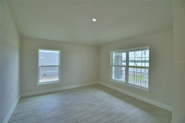 spare room featuring baseboards and light wood-style flooring
