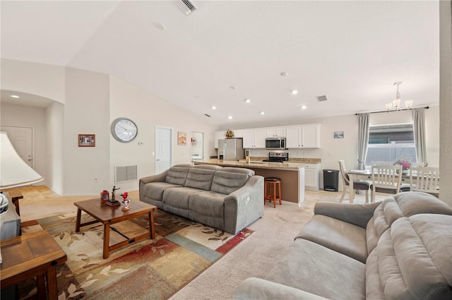 living area featuring arched walkways, a notable chandelier, visible vents, and recessed lighting