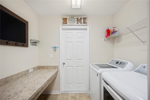 laundry room with separate washer and dryer, baseboards, laundry area, and a textured ceiling