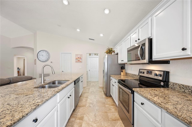 kitchen featuring a sink, lofted ceiling, stainless steel appliances, recessed lighting, and white cabinetry