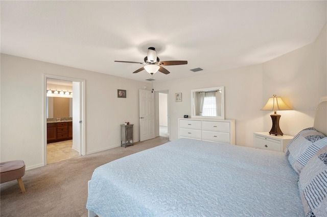 bedroom featuring visible vents, baseboards, ceiling fan, light colored carpet, and connected bathroom