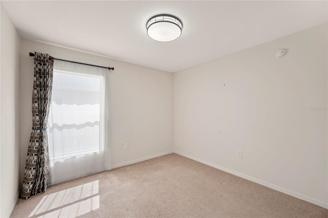 carpeted spare room featuring baseboards