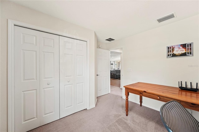 office area featuring visible vents, baseboards, and light carpet