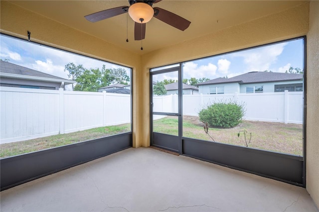 unfurnished sunroom featuring ceiling fan