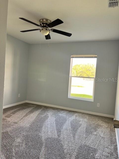 spare room featuring visible vents, baseboards, carpet floors, and ceiling fan