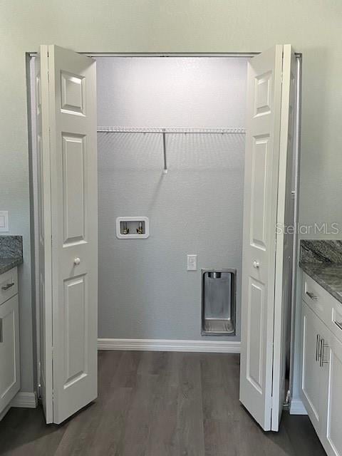 washroom with dark wood-style flooring, washer hookup, baseboards, and laundry area
