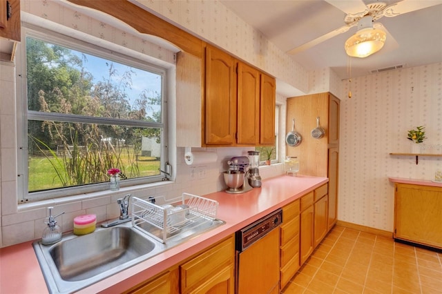 kitchen with wallpapered walls, a healthy amount of sunlight, visible vents, a sink, and dishwashing machine