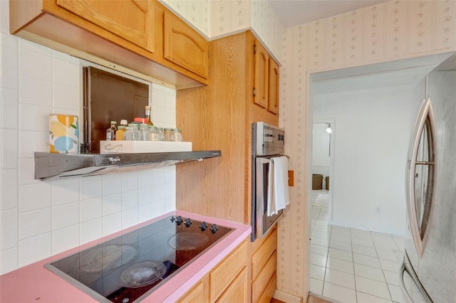 kitchen with stainless steel appliances, light tile patterned flooring, and wallpapered walls