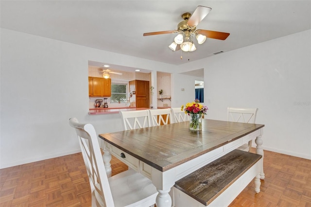 dining space with a ceiling fan, baseboards, and visible vents